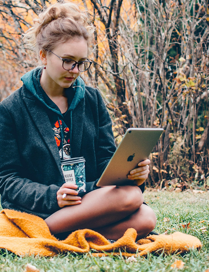 Girl using WiFi from Skyhook Solar Station to power iPad outside