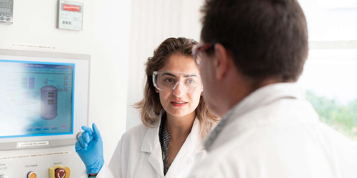 Female scientist talking to male colleague.