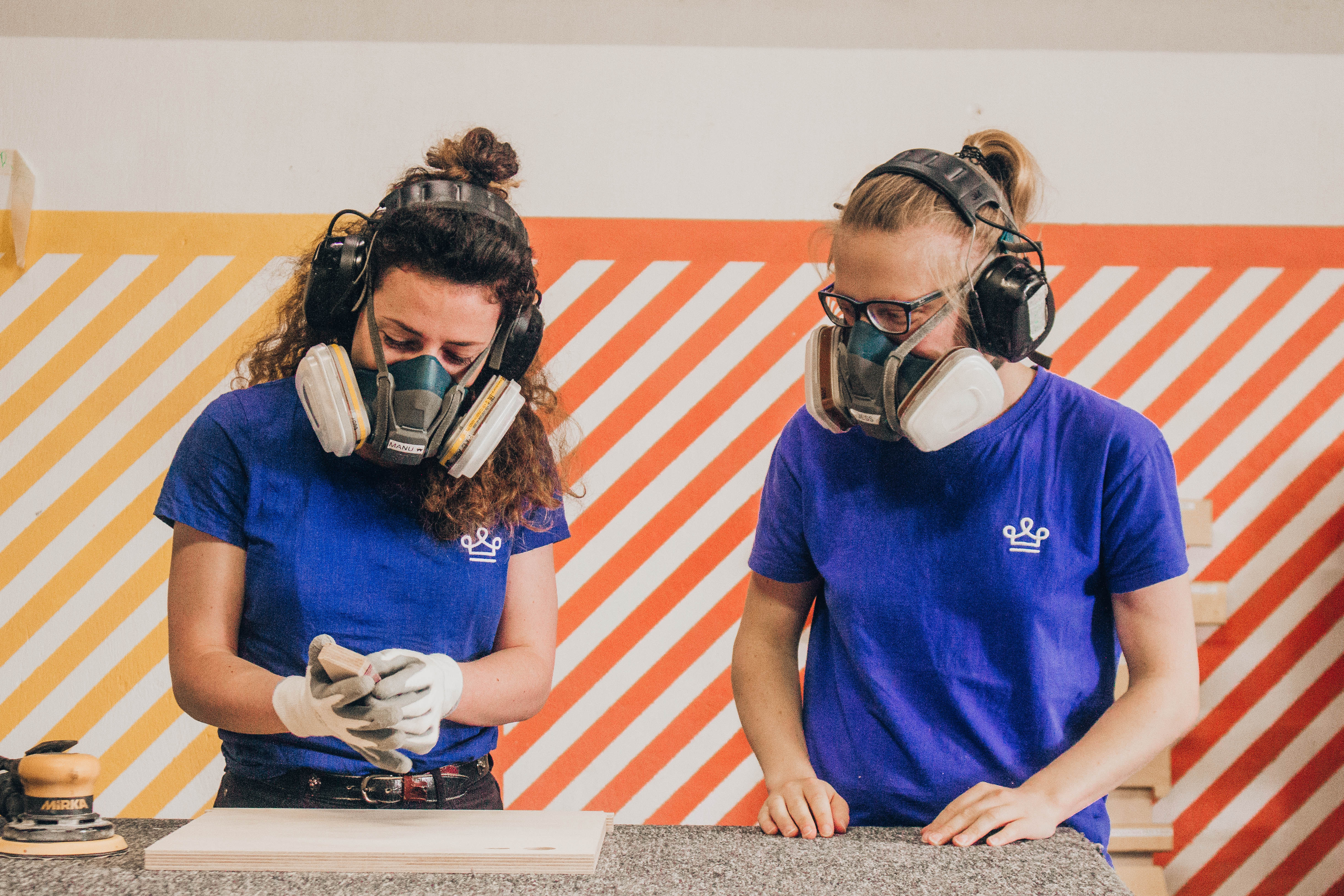 Deux femmes ébénistes dans un atelier de fabricant de mobilier de bureau qui font un onboarding