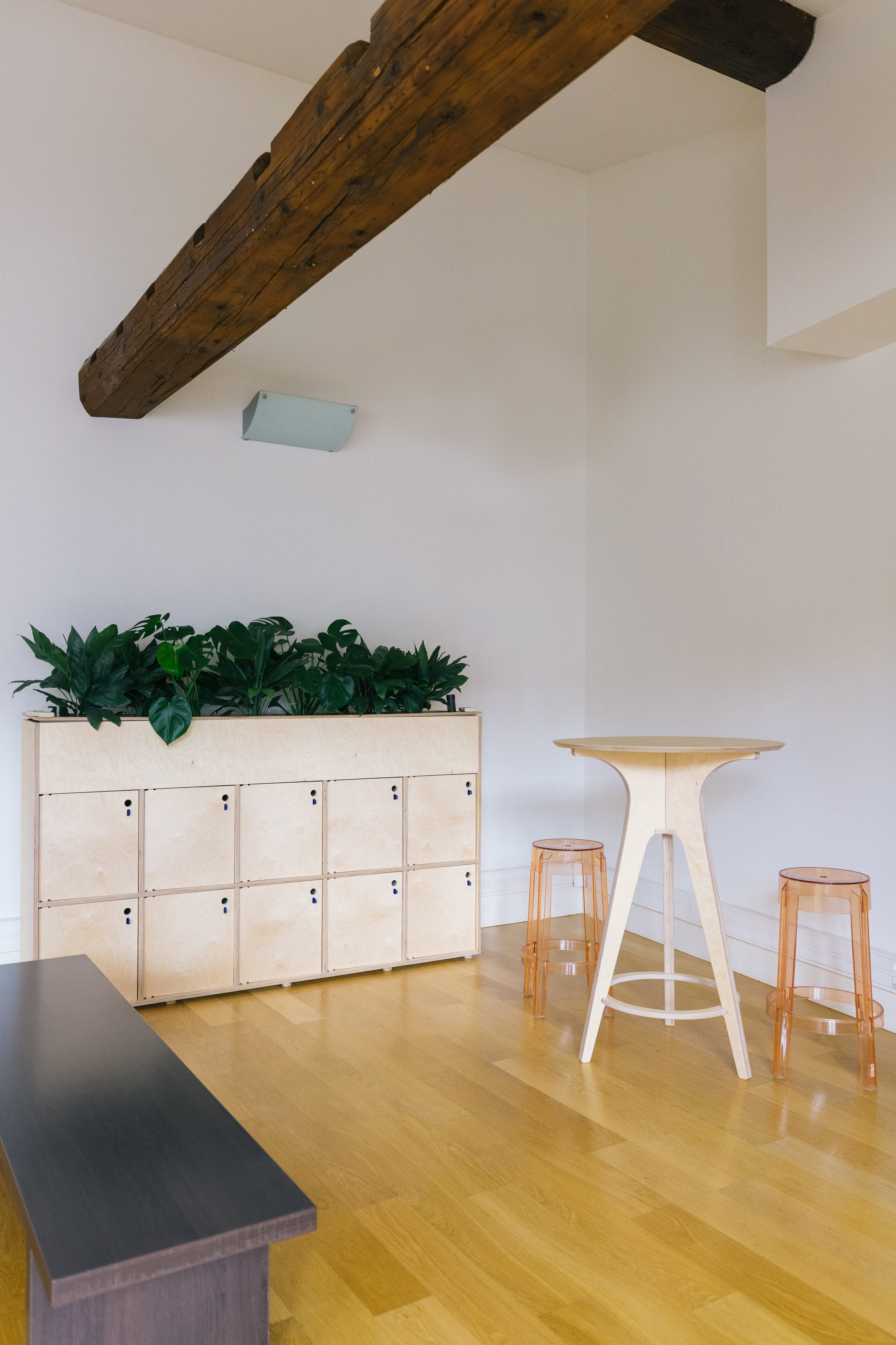 Aménagement d’un espace informel chez Malt avec une table haute et des casiers de rangement pour les partenaires