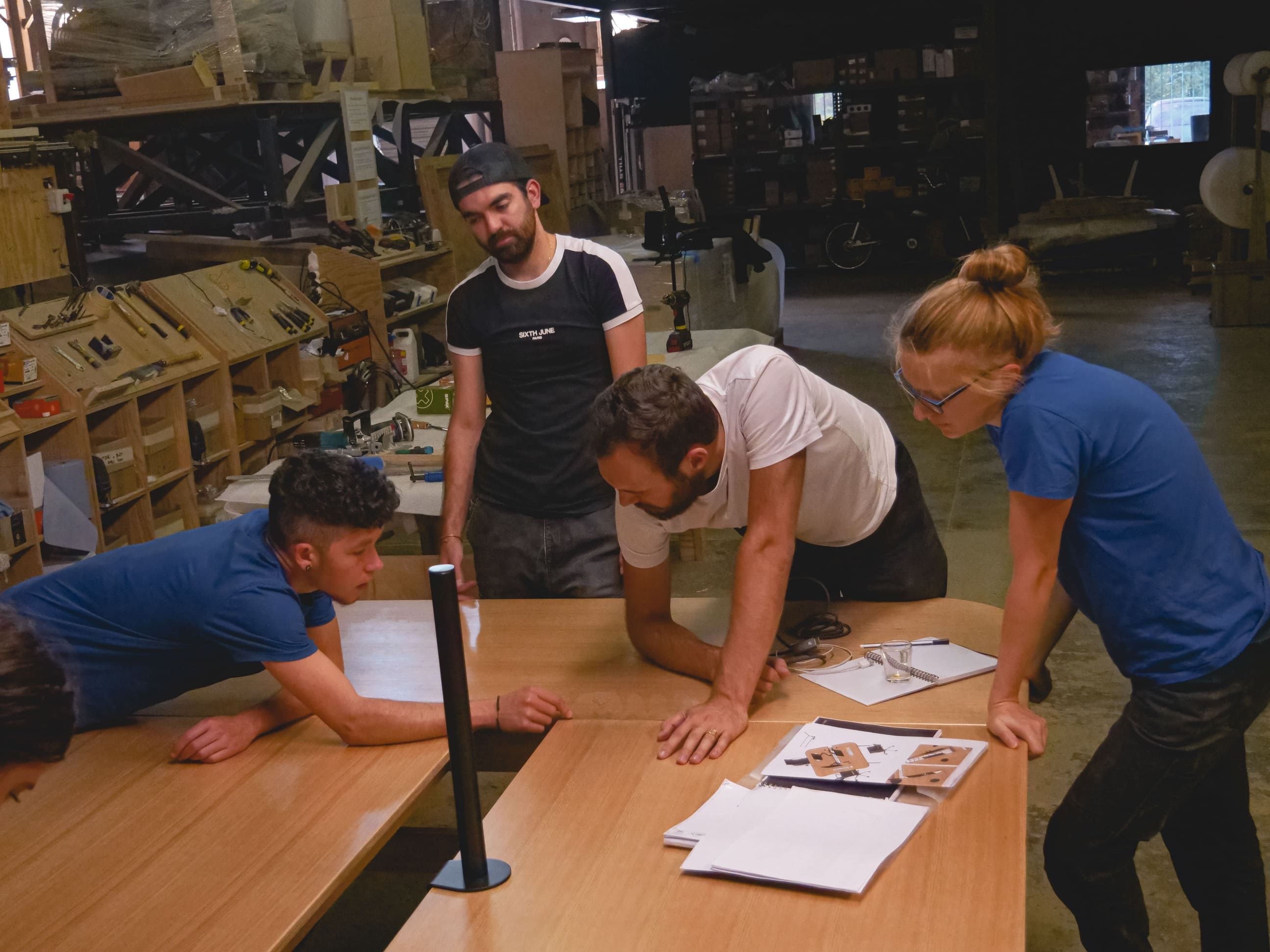 Une équipe travaillent dans un atelier sur la conception d'une table en bois sur-mesure