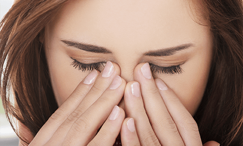 Woman holding her sinuses in pain