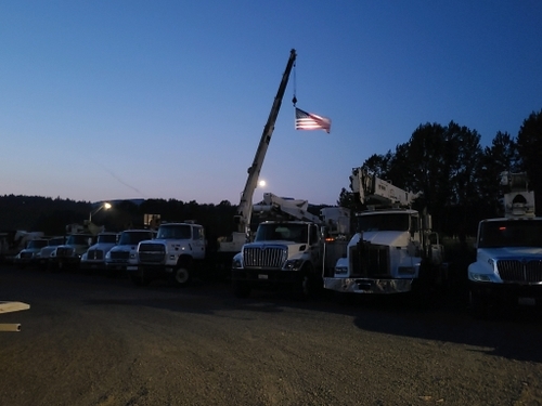 Industrial electric company fleet trucks with American flag