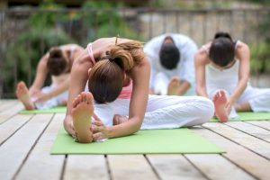 Group of people doing yoga exercises at the spa and relaxing