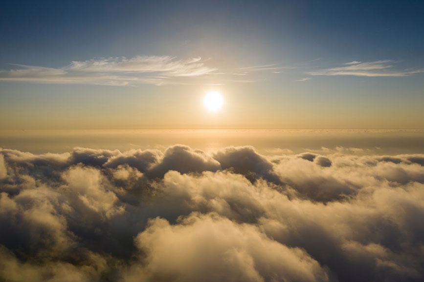 The sun setting above the clouds