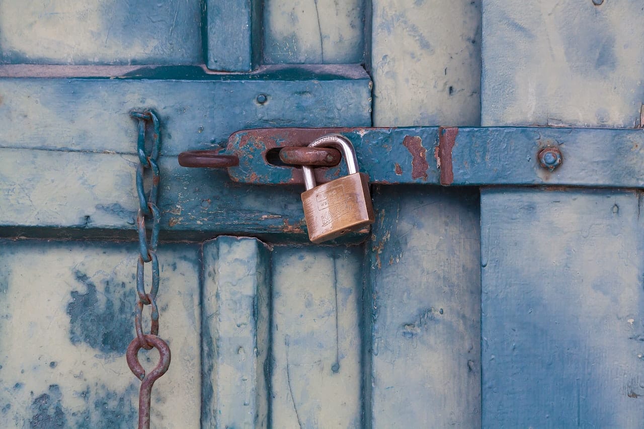 gold padlock securing a blue door