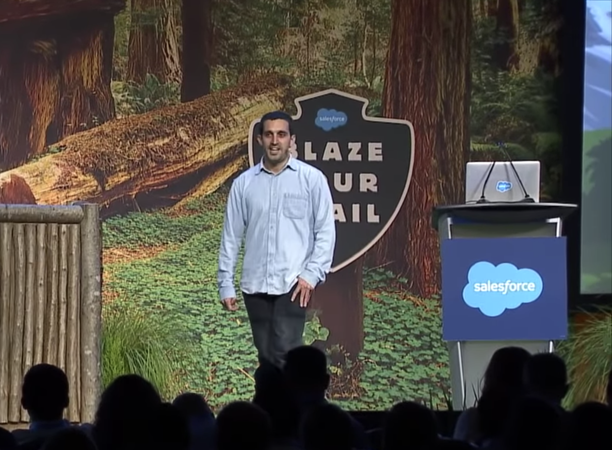 A person standing in front of a signDescription automatically generated with medium confidence
