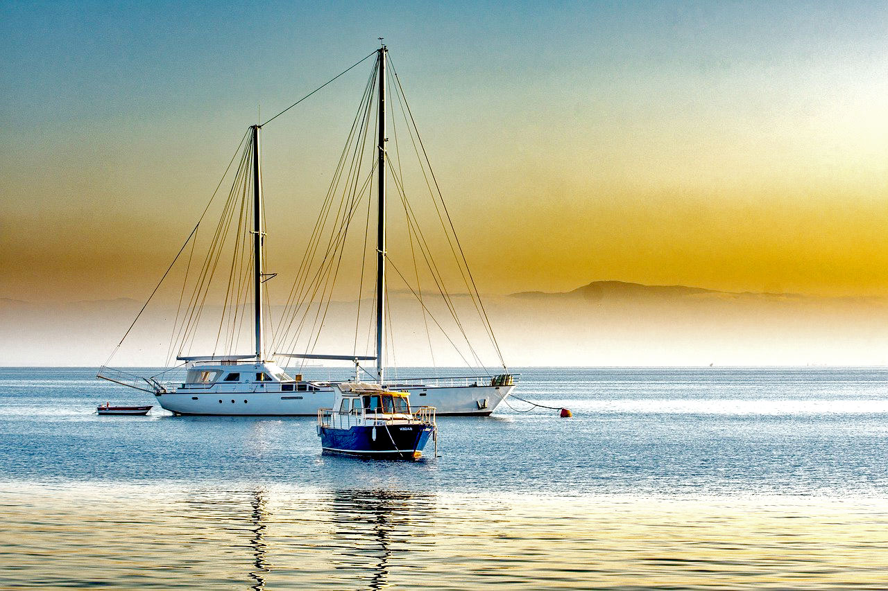 Imagem de um barco e um iate no mar