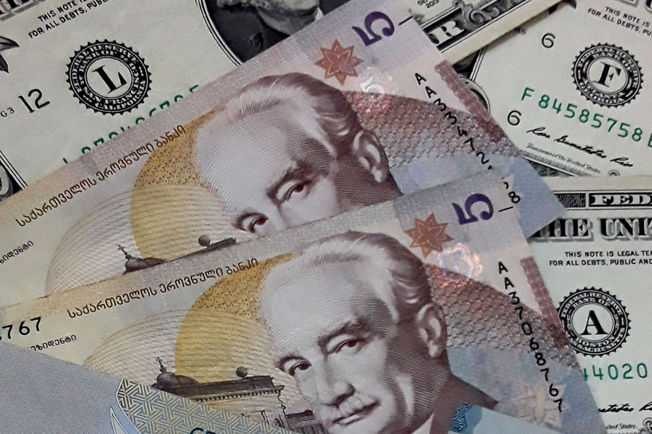 Imagem de cédulas de dólar e Lari espelhadas
