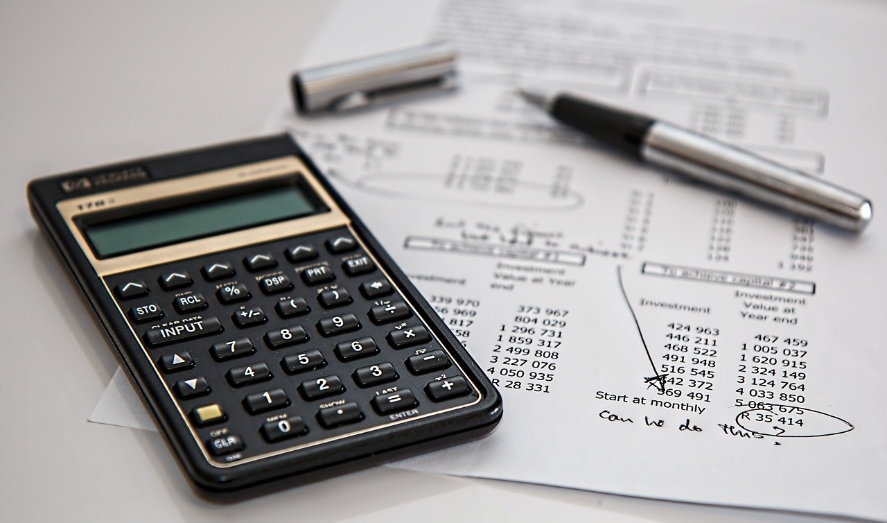 Imagem de uma calculadora ao lado de faturas ou boletos