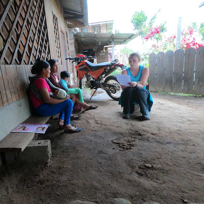 Go on your trip - Woman reading to two other women and a child