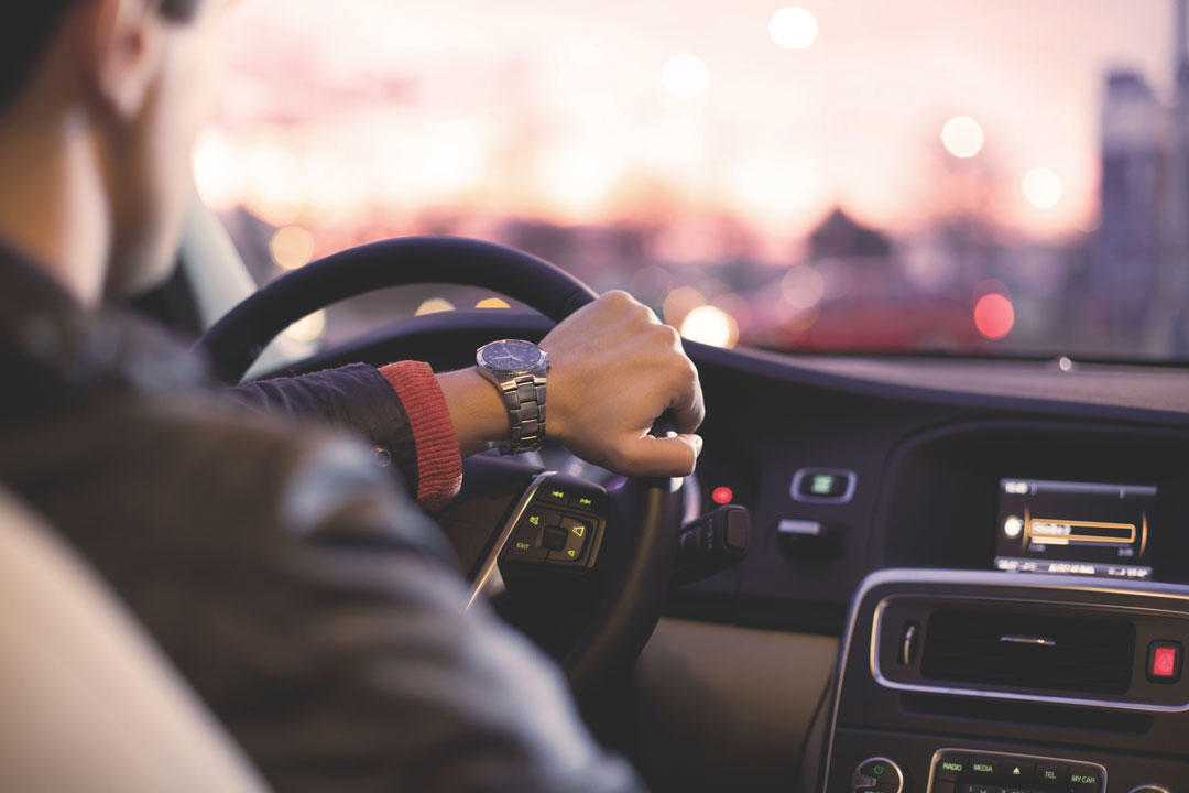 Close traseiro de homem dirigindo carro com a mão no volante