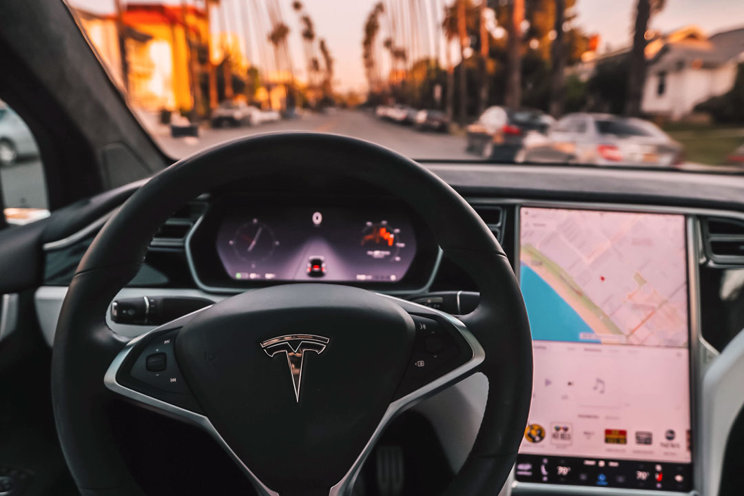 Close interno de carro Tesla mostrando o volante e central do sistema Autopilot
