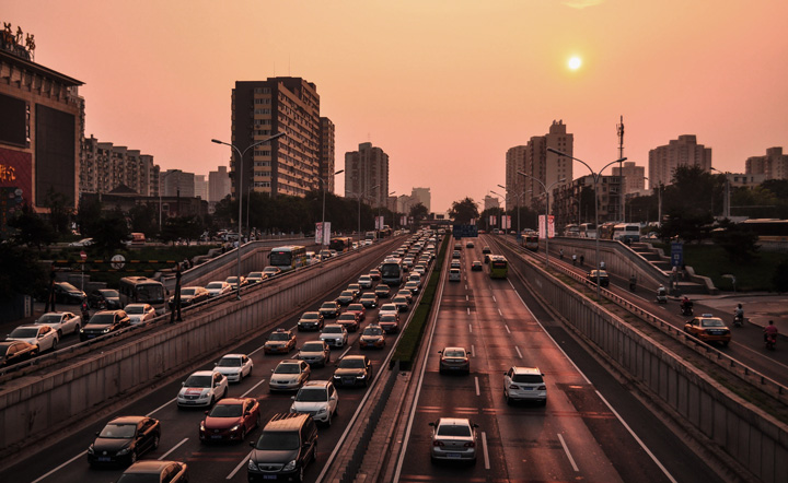 Entardecer em cidade grande com prédios e avenidas repletas de carros