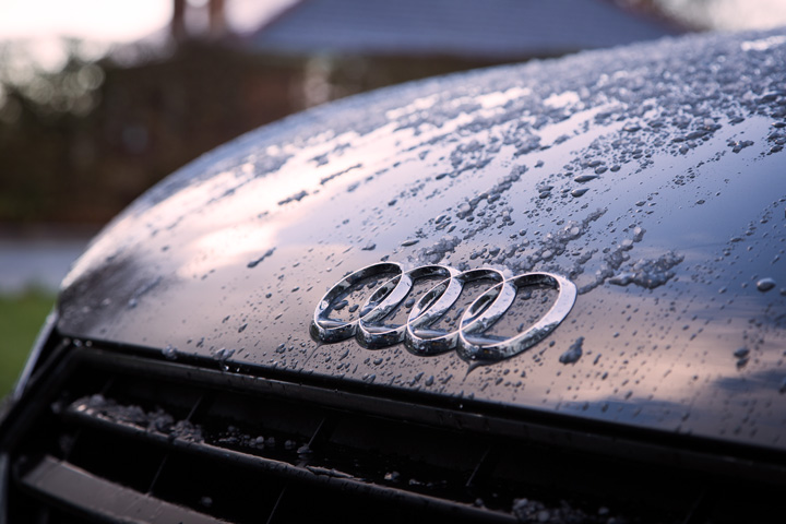 Close em capô de carro da Audi mostrando símbolo da marca