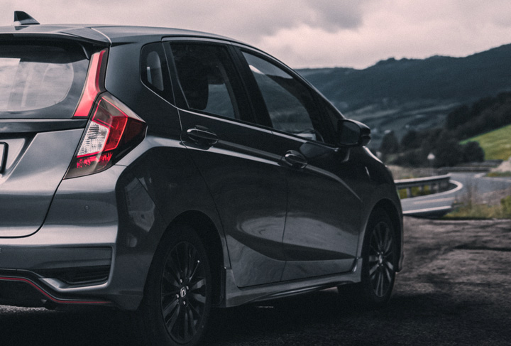 Visão traseira de Honda Fit parado em acostamento de rodovia