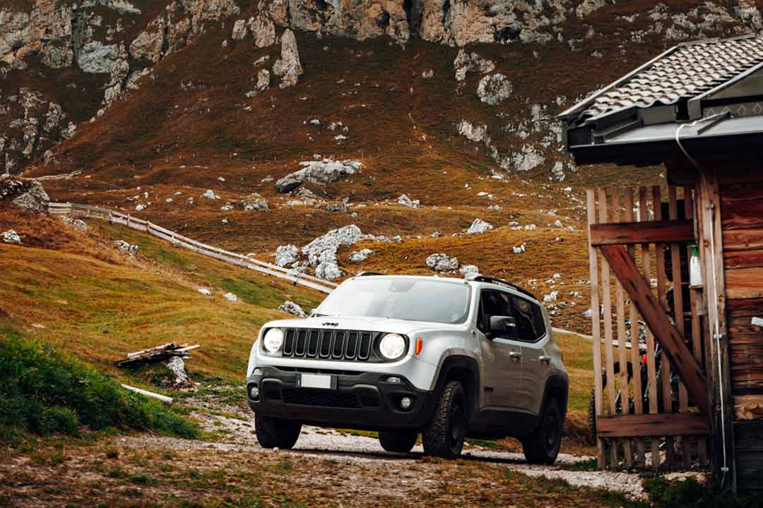 Jeep Renegade prata subindo ladeira em estrada de zona rural