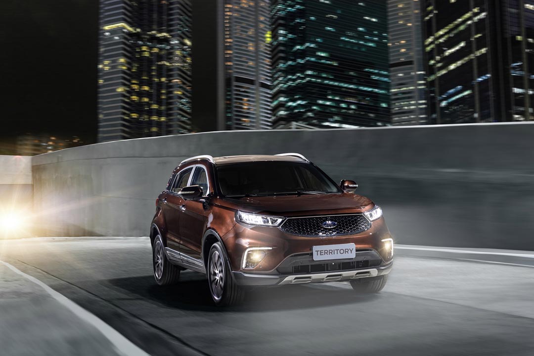 SUV Ford Territory em rua iluminada de uma cidade durante a noite