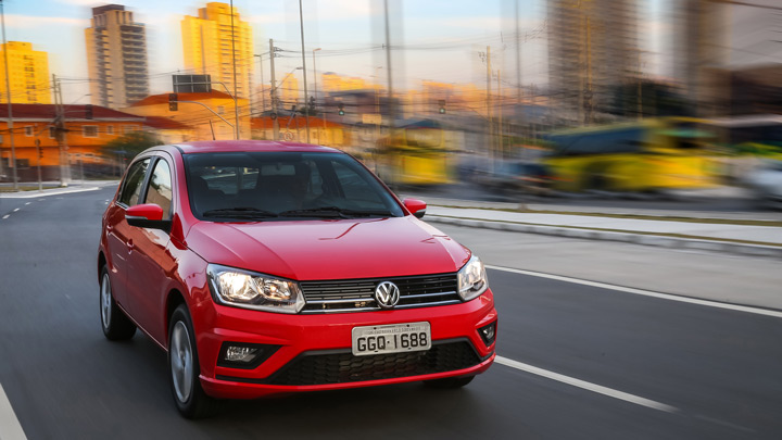 Carro Gol da Volkwagen transitando por rua de cidade ao final de tarde