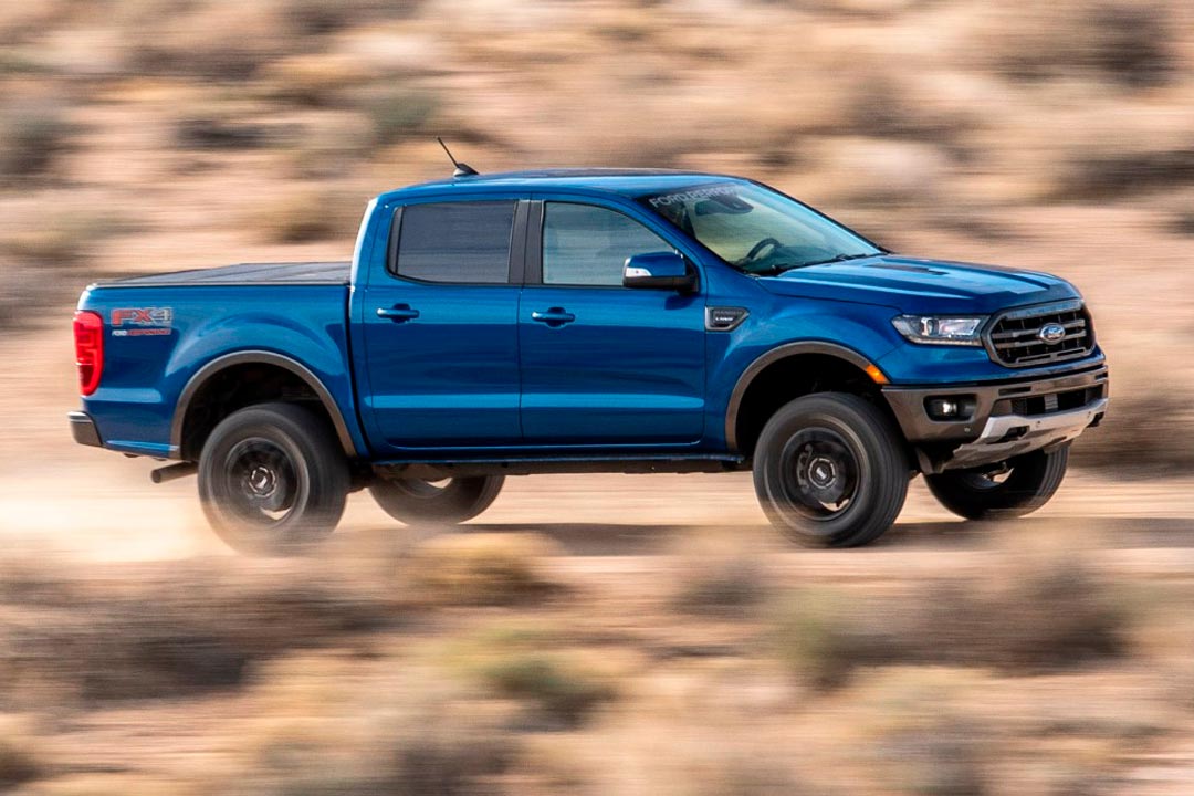 Picape Ford Ranger acelerando em estrada de terra e levantando poeira