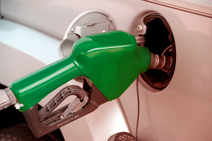 Destaque de bico de mangueira de combustível abastecendo tanque de carro