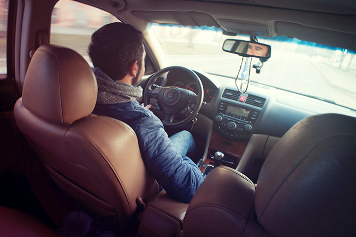 Vista traseira de um homem dirigindo carro e fazendo test drive