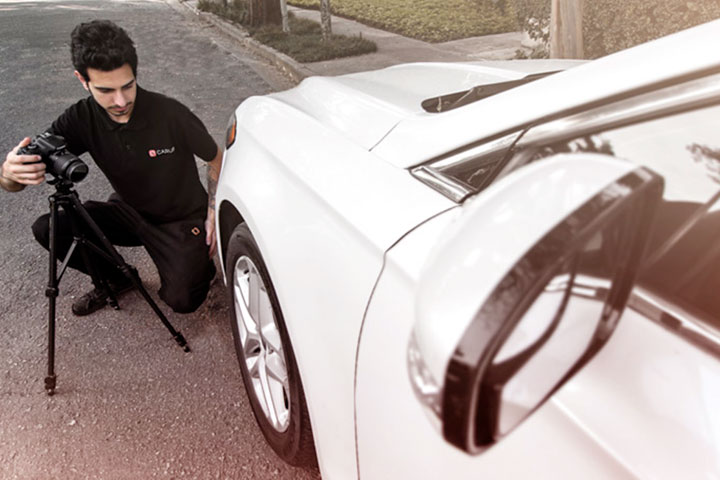 Fotógrafo da Carupi ajustando máquina fotográfica em tripé para fotografar carro usado para vender