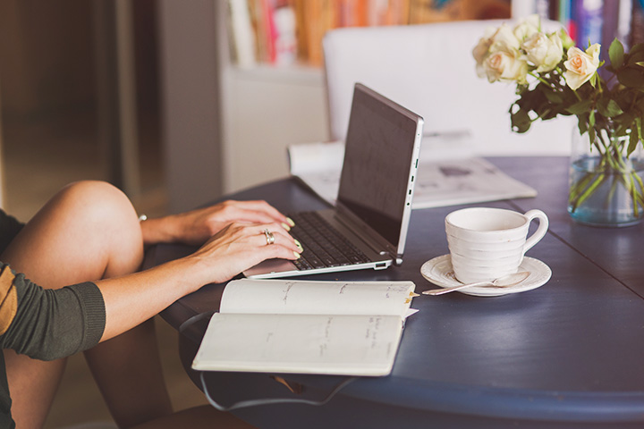 Jovem mulher em casa com notebook de mesa acessando website da CARUPI
