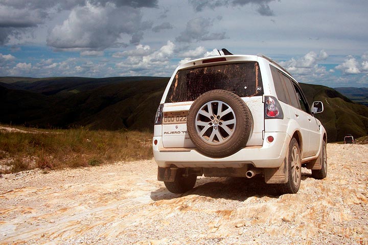 Mitsubishi Pajero TR4 branco em estrada rochosa no alto de montanha