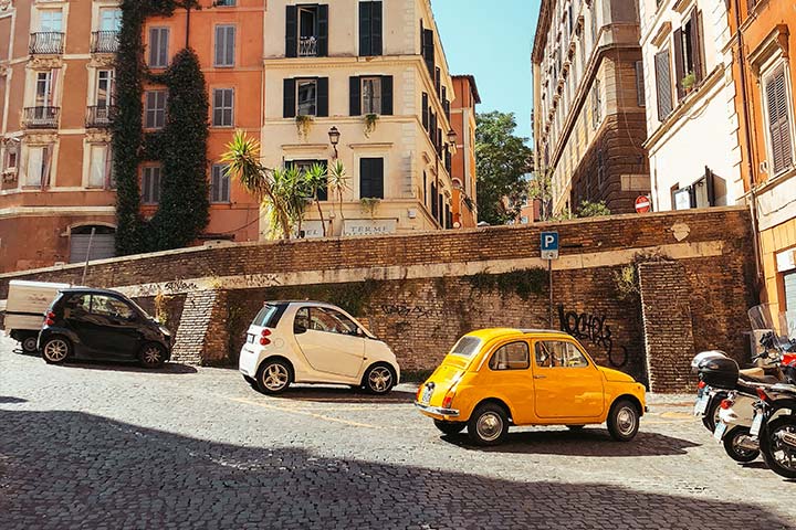 Cidade italiana com carros pequenos estacionados na rua