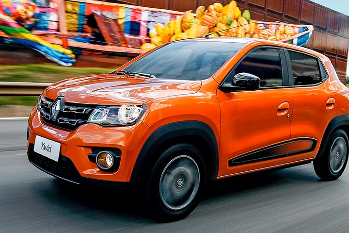 Renault Kwid em cor laranja trafegando em alta velocidade por avenida urbana