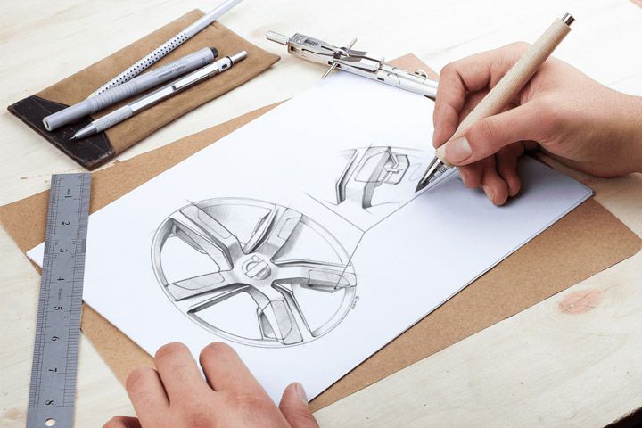 Close em mãos de projetista de carros desenhando esboço de roda em papel usando lápis e régua