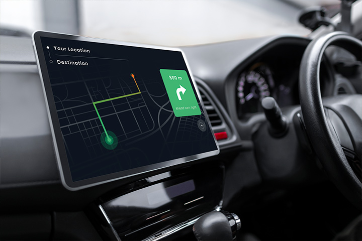 Console de carro mostrando volante e tela multimídia indicando mapa e rota de veículo