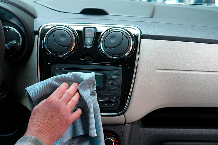 Console de carro sendo limpo por homem com flanela