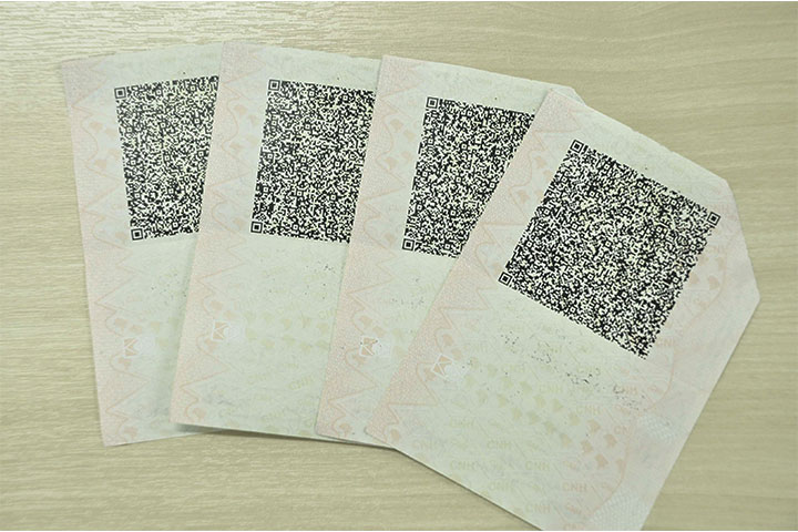 Grupo de quatro carteiras de habilitação viradas no verso mostrando código de segurança QR