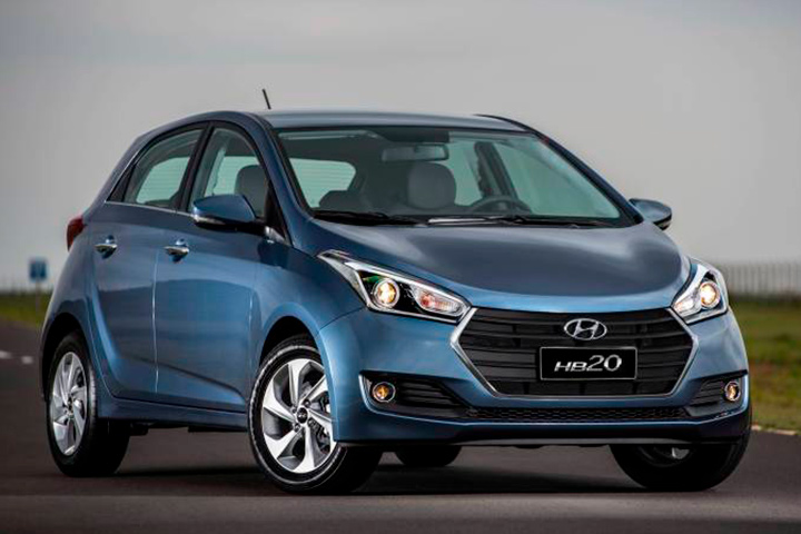Hyundai HB20 azul metálico parado em via de asfalto com cenário ao fundo
