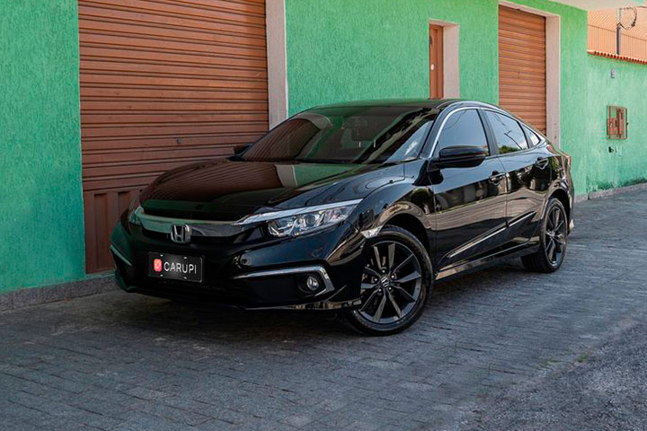 Honda Civic 2021 preto estacionado junto a prédio antigo com portas de ferro marrons e paredes verdes