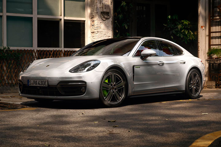 Porsche Panamera 2020 híbrido estacionado em rua tranquila em frente a lojas