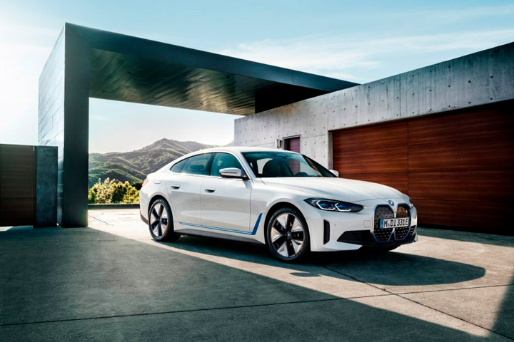 BMW i4 branco estacionado em pátio de garagem de casa contemporânea minimalista