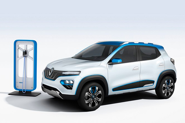 Renault Kwid elétrico branco com detalhes azuis em fundo infinito branco plugado a estação de carregamento de bateria