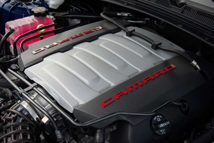Detalhe mostrando motor do Chevrolet Camaro ao lado de outras peças do veículo