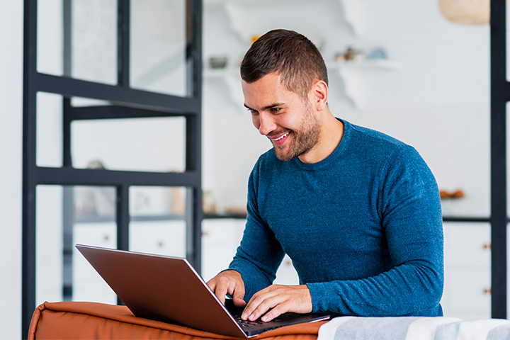 Jovem rapaz em sua casa acessando website Carupi em seu notebook
