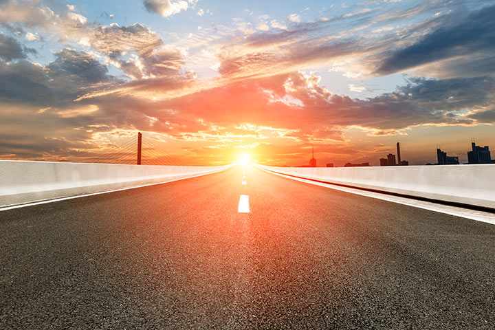 Rodovia vazia com asfalto quente brilhando com a luz do sol batendo nele