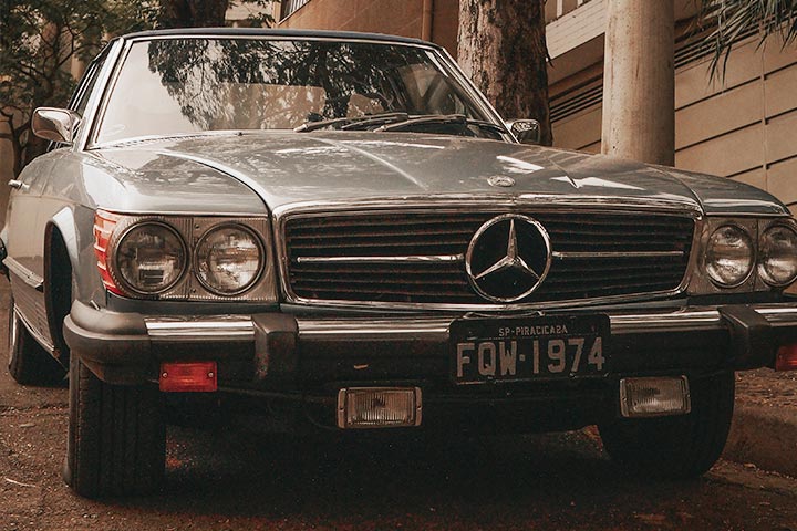 Frente de antigo carro Mercedes Benz com placa preta indicando originalidade