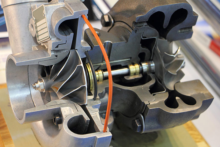 Turbo de carro cortado ao meio mostrando interior da peça e seus diversos componentes