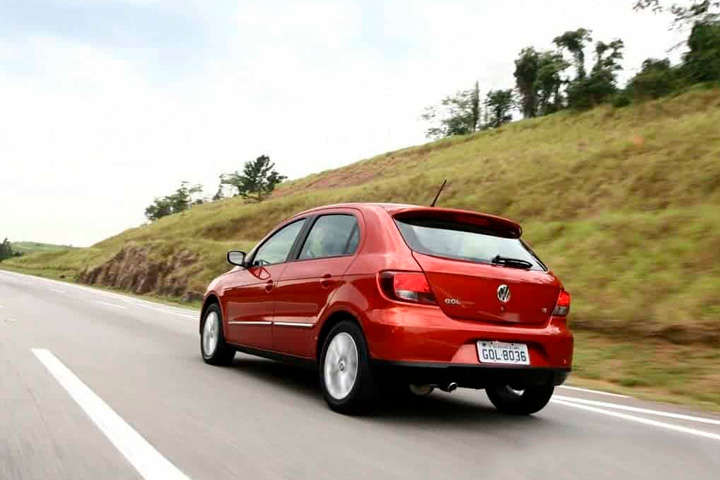 Gol G5 vermelho em alta velocidade em rodovia com barranco gramado ao lado