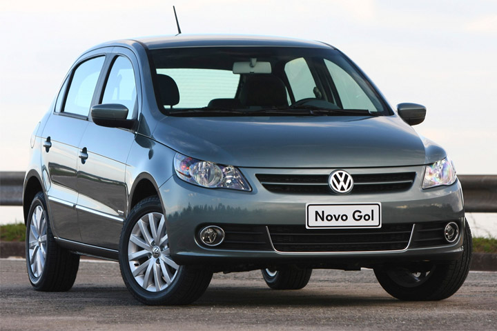 Gol G5 cinza esverdeado estacionado em pista com guard rail ao fundo