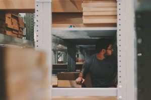 A man between storage shelves