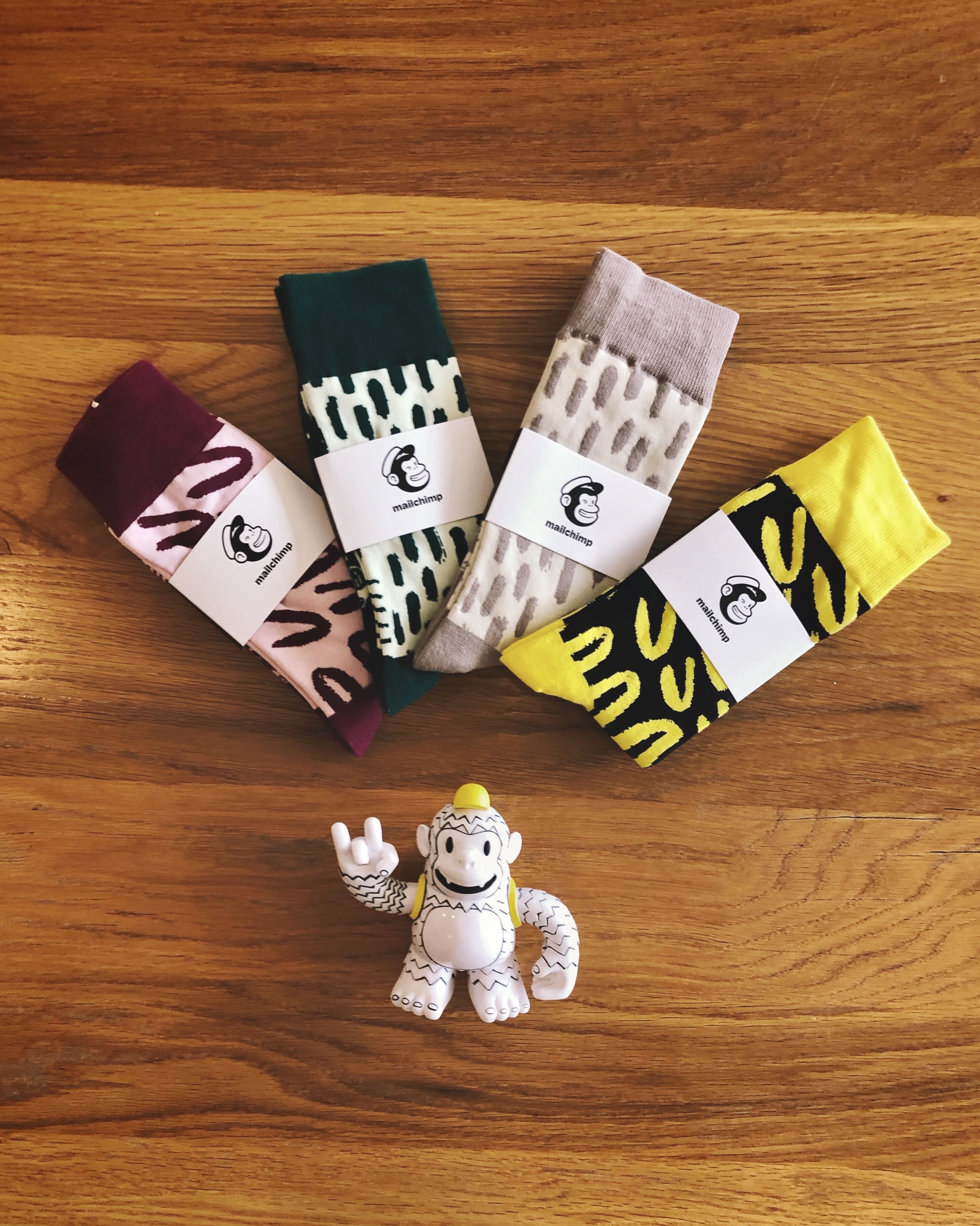 An assortment of Mailchimp swag including socks and a monkey.