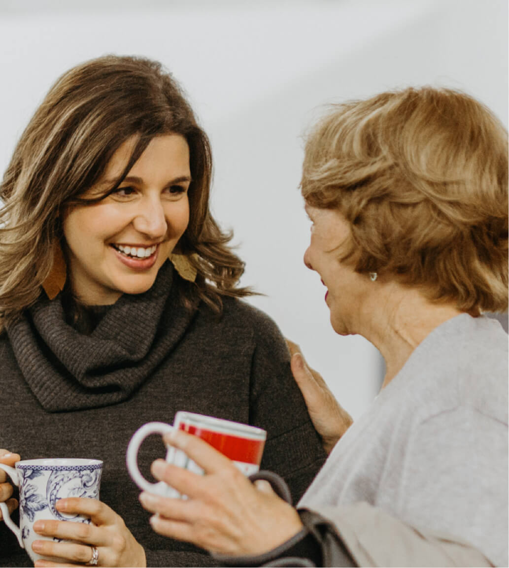 Two women talking and smiling at each other at Creative Mornings in Chattanooga.